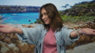Güneşli bir günde turkuaz deniz zeminiyle gezintiyi seven bir kadın gençlik neşesi ve macera sergiliyor..