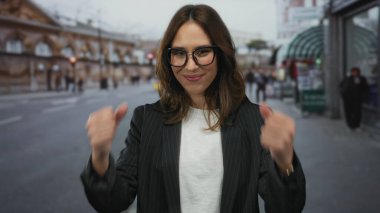 Şehir caddesinde kendine güvenen bir kadın coşkusunu ve mutluluğunu canlı bir şehir ortamında sergiliyor..