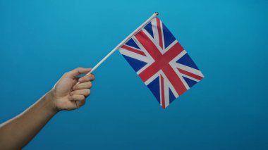 Mavi arka planda İngiliz bayrağını tutan erkek el, vatanseverliği ve milliyeti sembolize ediyor canlı ve basit bir tasarımla sendika krikosunu gösteriyor..