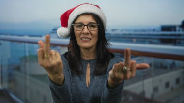 İspanyol kadın güvertede korkulukların önünde iki orta parmağını da gösteriyor..