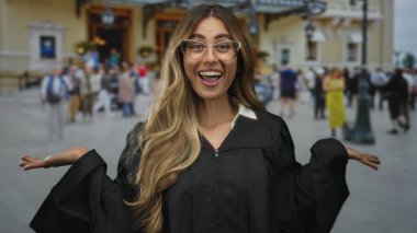 Gözlüklü kadın yargıç tarihi adliye meydanında avuçlarını açık gösteriyor..