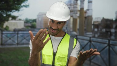 Genç İspanyol mühendis, antik Roma binasını açık elle çağırıyor. Açık havada harabeler, dostça karşılama..