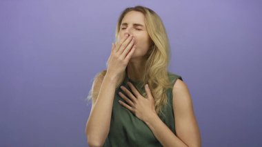 Stüdyoda öksüren bir kadın, genç sarışın bir kadını, hastalığın ve rahatsızlığın belirtilerini gösteren mor bir zemine dayadı..