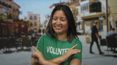 Yeşil gönüllü gömlekli genç bir kadın kalabalık bir şehir caddesinde neşeli bir şekilde gülümsüyor, toplum ruhunu ve nişanlanmayı kucaklıyor..