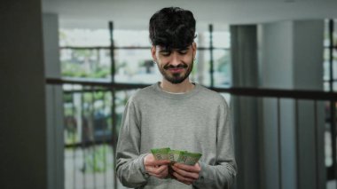 Modern bir otel ortamında elinde Rus rublesi banknotları tutan bir adam. Kapalı mekanlarda finansal işlemler sergiliyor..