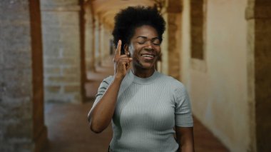 Tarihi üniversite koridorunda fikir jesti yapan kadın düşünceli bir ifadeden esinlenmiş gibi görünüyor. Günlük kıyafetler giyiyor, yaratıcılık ve zeka gösterisi yapıyor..