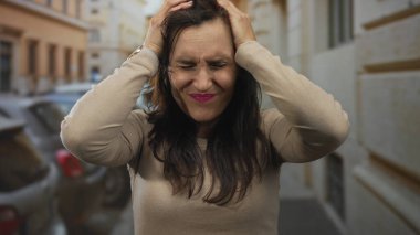 Sokakta duran kadın dışarıda duygularını ifade ediyor. Arka planda arabalar ve binalar var. Şehir yaşam tarzını, canlı ifadesini, Latin kültürünü, doğal ortamını sergiliyor..