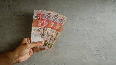 Elele tutuşan Hong Kong doları banknotları beton bir geçmişe karşı finans ve para aktarımı kentsel Hong Kong 'da