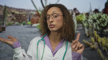 Steteskoplu kadın doktor yemyeşil park ortamında parmağı olduğunu belirterek arkasında bulanık yapraklar bıraktı..