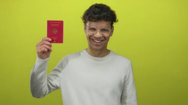 Yeşil stüdyoda yeşil zemine karşı elini kaldırmış Alman pasaportu taşıyan adam, gururlu..