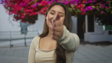 Kadın, tarihi korkulukları ve çiçek açan bougainvillea ile bir şehir caddesinde dostça bir el sıkışma için elini uzatır; dostça selamlaşma.