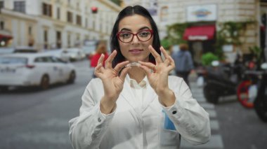 Üniformalı genç kadın diş hekimi yoğun bir sokakta görünmez diş telleri tutuyor..