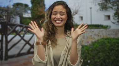 Açık havada gülümseyen, genç ve kaygısız bir kadın, güneşli bir açık havada mutluluğu ifade ediyor, gündelik ve neşeli..