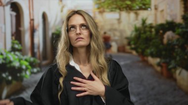 Kadın, şehir ortamında üniforma giyen genç sarışın yargıcın yanında hayal kırıklığına uğramış bir vaziyette göğüs göğüse sıkıştırıyor..