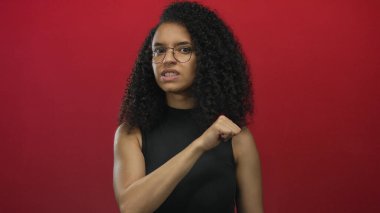 Genç bir kadın kırmızı stüdyo duvarını gösterip boğazını kesiyor. Tehdit uyarısı..