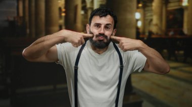 Sakallı İspanyol bir adam, katolik bir kilisede, jartiyer ve beyaz gömlek giyerek neşeli ve anlamlı bir atmosferi ön plana çıkaran neşeli ve şaşırtıcı bir ifade sergiliyor..