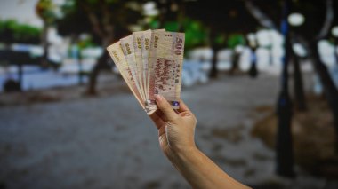 Kentsel alanda el ele tutuşan Tayvan banknotları bulanık sokak geçmişine karşı yatırım ve iş fırsatları sergiliyor..