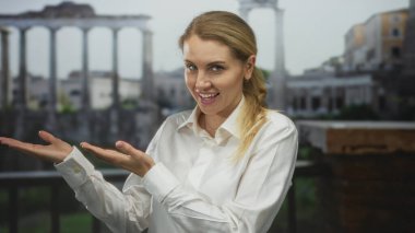 Roma harabelerini gülümseyerek sunan, beyaz bir gömlek giyen, açık havada tarihi mimariyi ön plana çıkaran, tarihi bir manzarada seyahat ve keşif yapan bir kadın..