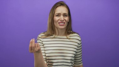 Mor stüdyoda elini büzüşmüş dudaklarıyla kaşlarını çatarak, hayal kırıklığıyla işaret eden bir kadın..