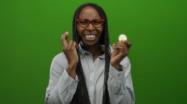 Cardano sikkesi tutan kadın yeşil arka planda umut verici bir ifade ve gözlük takan ve çizgili gömlek giyen yatırım beklentilerini sembolize ediyor..