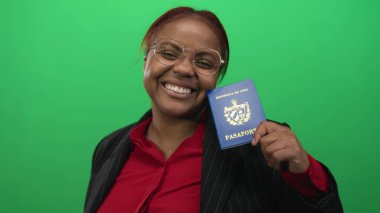 İnce çizgili ceketli kadın yeşil stüdyoda poz veriyor; keyif yolculuğu özgürlüğü arzusu.