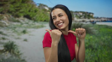 Neşeli bir park ortamında güvenle gülümseyen bir kadın güneşli bir günde yeşil ve kaygısız bir hava yaratarak neşeli bir açık hava yaratıyor.