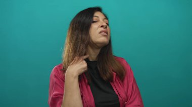 Orta yaşlı İspanyol kadın bir stüdyoda el dürbünü hareketi yaparak tetikte bekliyor..