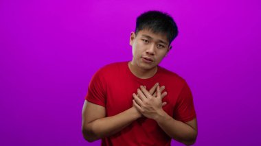 Soyutlanmış pembe bir geçmişi olan genç bir adam. Elleri kalbinde. Minnettarlığını ya da minnettarlığını ifade ediyor..