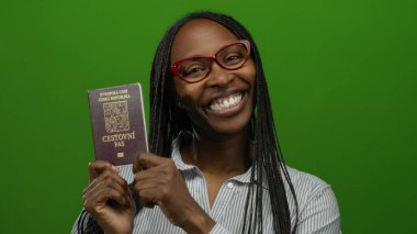 Yeşil arka planda Czech pasaportu taşıyan gülümseyen kadın, örgülü ve gözlüklü seyahat belgesi sergiliyor..
