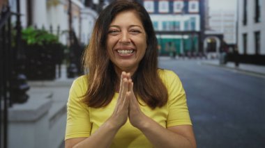 Kadın sabah güneşinin altında yumruklarıyla gülüyor ve gülümsüyor..