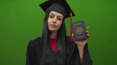 Mezuniyet elbisesi giymiş bir kadın yeşil arka plana karşı Meksika pasaportu taşıyor, başarıyı ve küresel hedefleri simgeliyor..