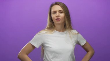 Beyaz gömlekli hayal kırıklığına uğramış genç kadın, yoğun jestler ve ciddi yüz ifadeleri ile izole edilmiş mor arkaplana olan kızgınlığını dile getiriyor, duyguları ve tavırları vurguluyor..