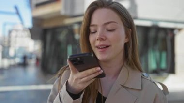 Meşgul bir şehir sokağında akıllı telefonu ağzına alan kadın, gözler ileride, bağlantı.