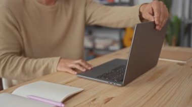 Adam dizüstü bilgisayarı ayarlar ve merkez ofise İspanyol bir bilgisayar serbest çalışanı olarak yazmaya başlar, mutlu bir şekilde gülümser..