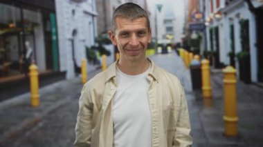 Canlı bir şehir caddesinde, alnında parmaklarıyla el kol hareketi yapan bir adam, şehir ortamında sıradan, dostane bir titreşim uyandırıyor..