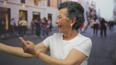 Canlı bir şehir sokağında gülümseyen, hayat dolu şehir atmosferini yakalayan, gri saçlı yaşlı kadın..