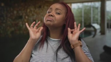 Kızıl saçlı, gülümseyen bir kadın, iki elini de havuz kenarına, spa alanına koyduğunda iyi bir işaret veriyor. Onaylandı..