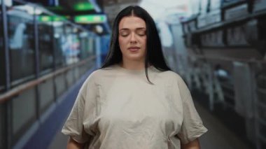 Gemi güvertesinde meditasyon yapan bir kadın, gözleri kapalı, huzurlu bir çevrede, açık deniz yolculuğu sırasında sakin ve düşünceli olduğunu ifade ediyor..