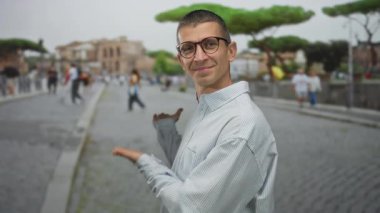 Gözlüklü bir adam ünlü İtalyan caddesinde insanlarla el kol hareketi yapıyor. Roma 'nın tarihi kaldırım taşı ayininde güneşli bir günde canlı bir şehir hayatı sergiliyor..