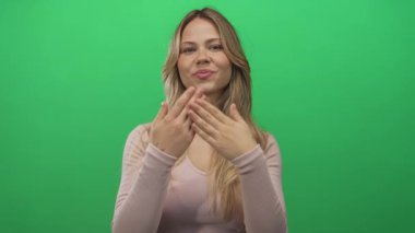 Uzun saçlı kadın avuç içlerini açar ve fotoğraf stüdyosunda nazikçe gülümser..