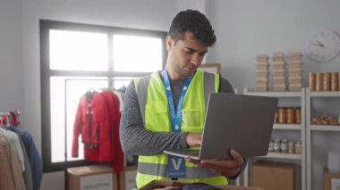 Adam merkezde yazı yazarken dizüstü bilgisayar kullanıyor. Genç İspanyol gönüllü, erkek asistanının yardımlarıyla yardım topluyor..