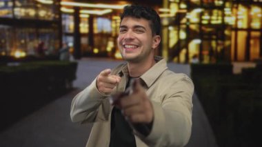 Bir adam, şehir merkezindeki bir bölgede gece vakti genç bir İspanyol 'un parmakla gökyüzünü gösterirken parmağını tutuyor..