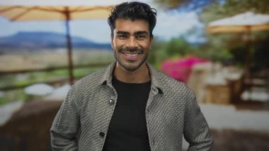 Adam yaz güneşinin altında bir restoranın terasında alnını hafif bir gülümsemeyle siliyor..