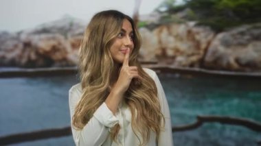 Sahilde sessizlik için kadın parmakları dudaklara; gizem.