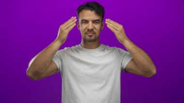 Genç İspanyol asıllı bir adam, nötr bir gömleğin içindeki farklı ve canlı duyguları ortaya çıkaran bir dizi dinamik çerçevede canlı, mor bir arkaplan üzerinde şaşkınlığını dile getiriyor.