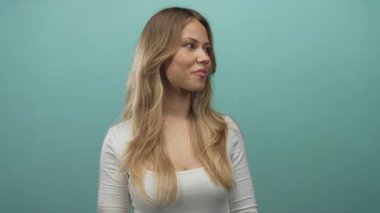 Stüdyoda başını sağa çeviren ve sırıtan sarı saçlı bir kadın. Mutluluk mutluluğu..