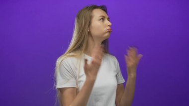 İzole edilmiş mor arka planda ateşli hisseden bir kadın, jestlerden ve yüz ifadelerinden rahatsızlık duyuyor, günlük beyaz gömlek giyiyor..