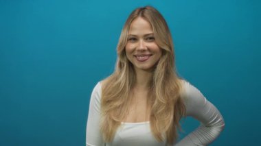 Stüdyo resminde eli kalçasında beyaz saçlı, uzun sarı saçlı bir kadın. Kendine güveni sevinç iyimserliği..