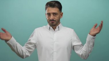 Gıcır gıcır beyaz gömlekli adam iki elini kaldırır ve bir gök mavisi stüdyosunda başını hafifçe eğer..