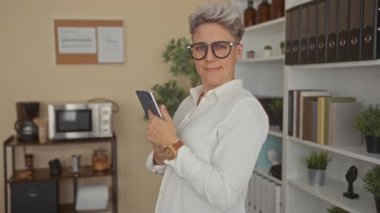 Kadın modern ofis binasında tablet tutarken el sıkışmak için elini uzatıyor; dostane olumlu karşılama.